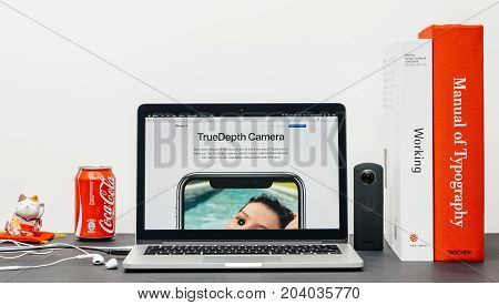 PARIS FRANCE - SEP 3 2017: Minimalist creative room table with Safari Browser open on MacPook Pro laptop showcasing Apple Computers website with latest iPhone X 10 with Truedepth new camera