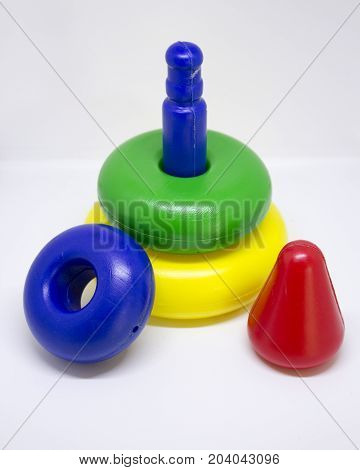 Cheap colored plastic pyramid toy on white background