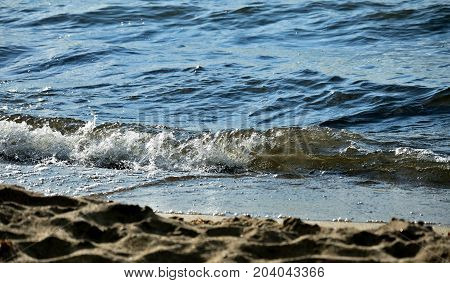 noisy wave is incident on the shore of the lake, fly spray around, South Ural, Uvildy