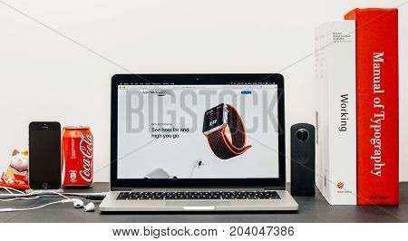 PARIS FRANCE - SEP 13 2017: Minimalist creative room table with Safari Browser on MacBook Pro laptop at Apple Computers website with latest Apple Watch Series 3 with GPS and Altimeter