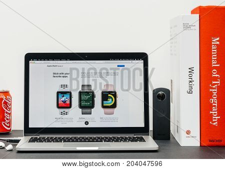 PARIS FRANCE - SEP 13 2017: Minimalist creative room table with Safari Browser open on MacBook Pro laptop at Apple Computers website with latest Apple Watch Series 3 with swiming and running apps