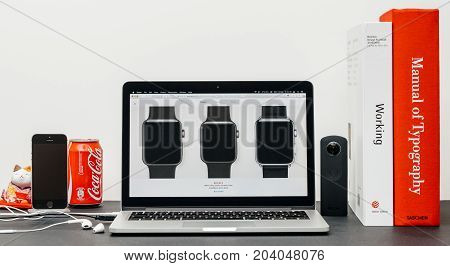 PARIS FRANCE - SEP 13 2017: Minimalist creative room table with Safari Browser open on MacBook Pro laptop at Apple Computers website with latest Apple Watch Series 3 with selction of apple watch face band