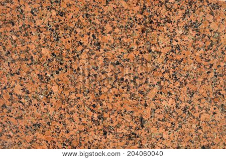 Facing material red granite texture. Natural stone red granite background texture. Bright hard red granite rock texture. Red granite stone background texture. Red granite untreated surface. Facing material full frame horizontal red granite texture.