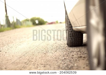 the wheel of a car on a dirt road with blurred background