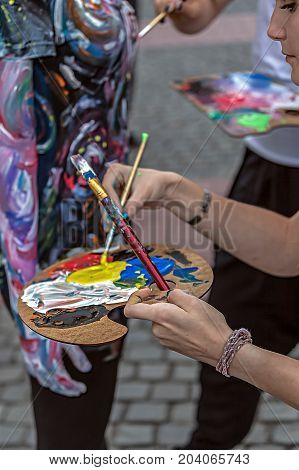 TIMISOARA ROMANIA - SEPTEMBER 8 2017: Girls make body painting of a woman. 3D art symbolizing on live at the street inside the CheckART Carnival organized by the City Hall Timisoara. Liberty Square