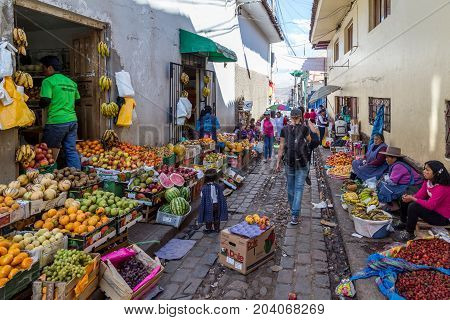 Cusco, Peru - August 08, 2015: People selling and buying fruits at a market in the steets