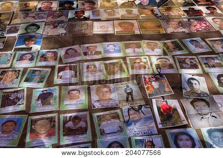 December 3 2014 San Cristobal de las Casas Mexico: photos of central American refugees who dissapeared while crossing Mexico laid out on the ground during a demonstration