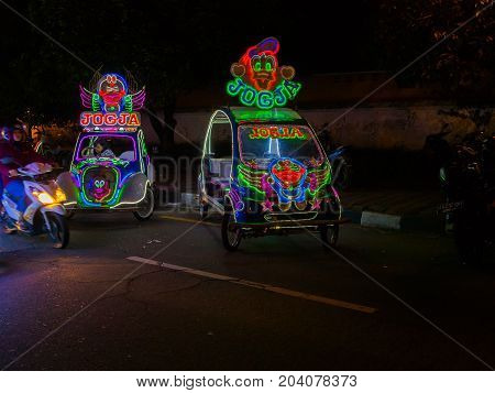 JOGJA, INDONESIA - AUGUST 12, 2O17: A traditional pedicap transport parket at outdoor with colorful and bright lights at night at jogja Yogyakarta Indonesia.