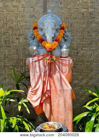 BALI, INDONESIA - MARCH 11, 2017: Hindu Balinese shrine with a statue or stone sculpture of Ganesha, the elephant god, iin Ubud, Bali.