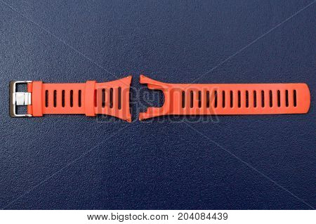 Orange watchband rubber skin & repairing tool kit for adjusting watchband on isolated blue background.