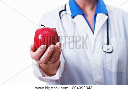 Female doctor holding an apple isolated on white.