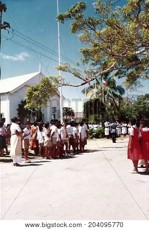 NUKU'ALOFA, TONGATAPU / TONGA - CIRCA 1990: Children in school uniforms gather to watch a parade during a national holiday.