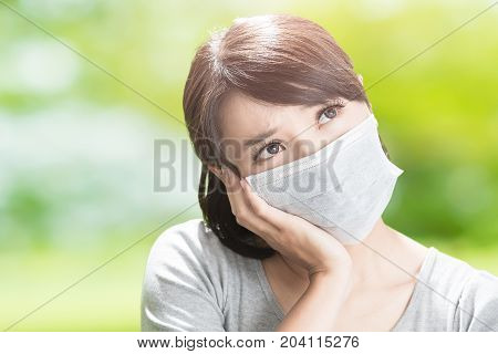 woman feel bad and look somewhere on the green backgorund