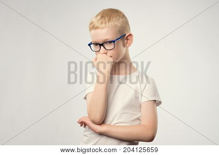 Caucasian teenager with blond hair and glasses thinking isolated on white for copy space