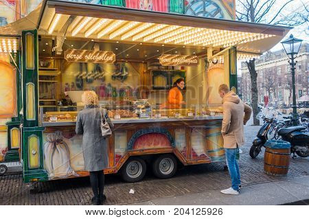 The Hague the Netherlands - 26 November 2016: people buying fresh oliebollen at a street vendor in The Hague
