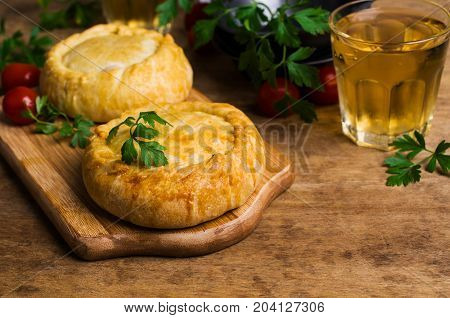 Round meat pie with vegetables and spices on a wooden background. Selective focus.