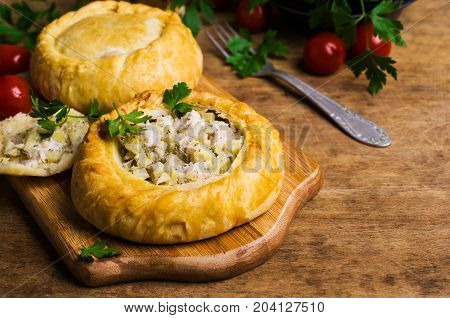 Round meat pie with vegetables and spices on a wooden background. Selective focus.