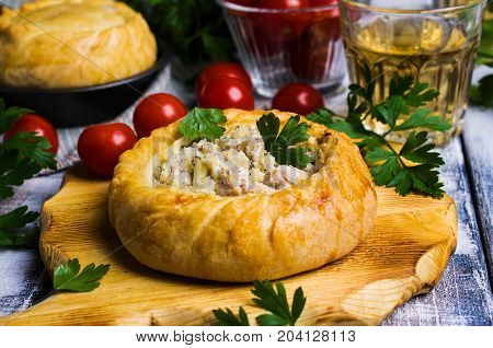 Round meat pie with vegetables and spices on a wooden background. Selective focus.
