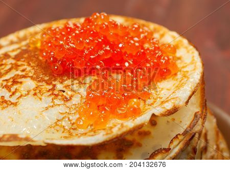Traditional Russian pancakes with red caviar close up