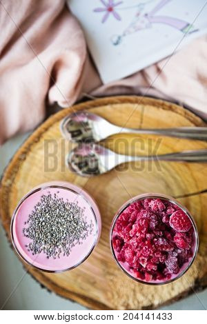 Chia and frozen raspberies cottage cheese breakfast in two small transparent glasses