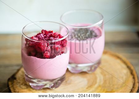 Chia and frozen raspberies cottage cheese breakfast in two small transparent glasses