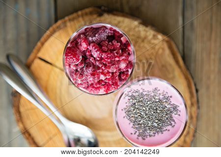 Chia and frozen raspberies cottage cheese breakfast in two small transparent glasses