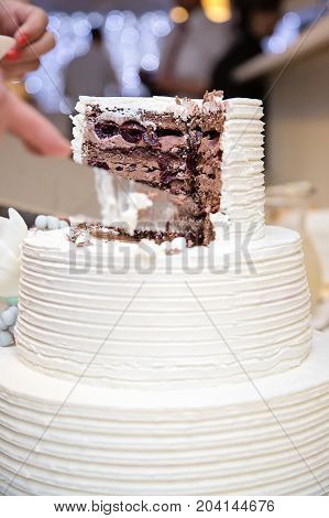 White wedding cake sliced open with cholate and black cherry filling