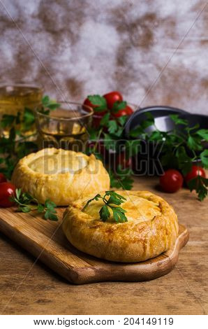 Round meat pie with vegetables and spices on a wooden background. Selective focus.
