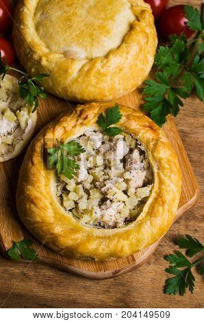 Round meat pie with vegetables and spices on a wooden background. Selective focus.