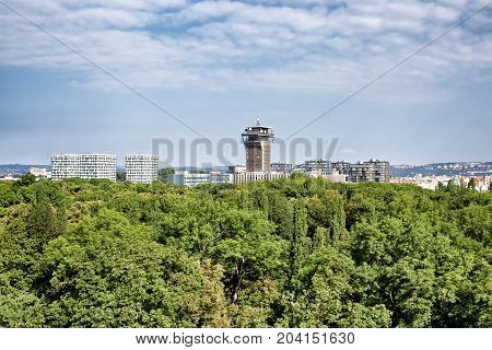 View on Olsany Jewish Cemetary covered by dense stand of trees and city architecture at the background Prague Czech Republic Prague 3 area