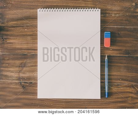 White paper and pen for scetch on the wood background