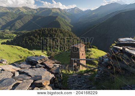 Georgian defensive towers in the mountain village Omalo. Traditional architecture in Georgia. Landscape of Caucasus mountains with Tusheti towers at the forground in summer