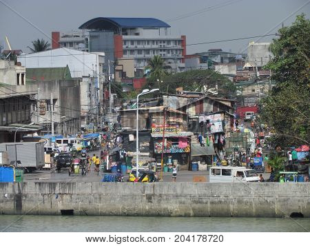 Manila Philippines, 10 February 2015: Street view in poor neighborhood in Manila with people walking in the street