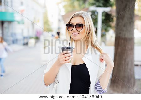Relaxed Stylish Woman Drinking Coffee Outside On Urban Background