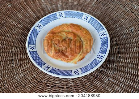 Greek spiral pie traditionally stuffed with cheese leek or spinach. Vegetarian food appetizer dish.