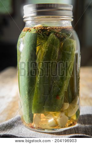 Homemade rustic organic pickled cucumbers on wooden table