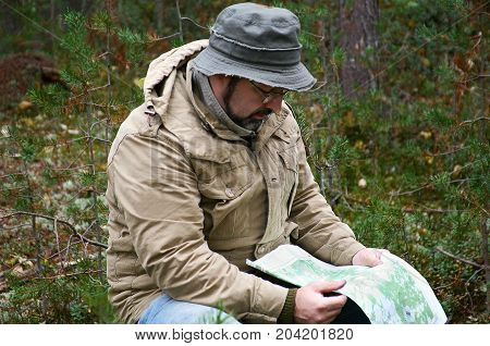 Hiker With Map In Forest