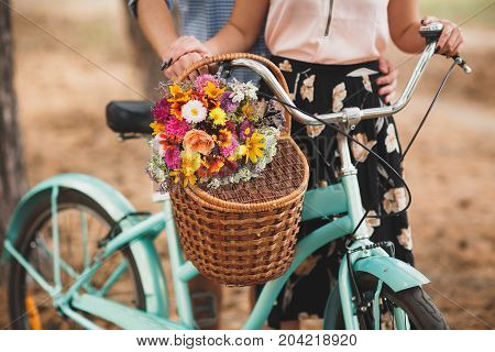 Close-up image of body parts cute girl and boy. with bright gift, standing in the forest with bicycle. Lifestyle concept.