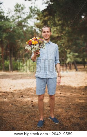 Full length photo of cute boy. with bright gift, standing in the forest. Lifestyle concept.