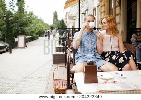 Young Couple Talking at Coffee Shop on a date. Loving couple having fun at a restaurant.