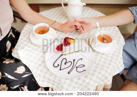 A young couple ordered a cheesecake in a cafe.