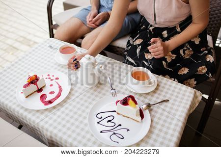 A young couple ordered a cheesecake in a cafe.