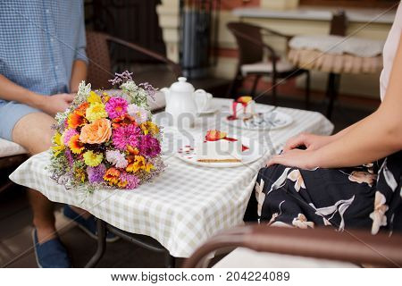 A young couple ordered a cheesecake in a cafe.