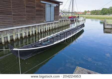 Roskilde Denmark - August 01 2015: replica of ancient boat and visitors outside the Vicking Ship Museum