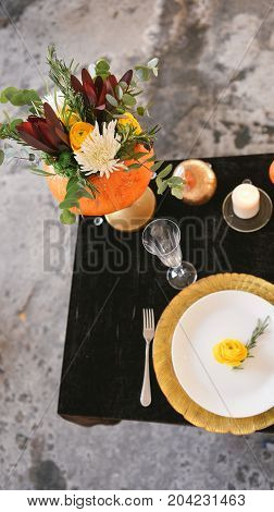 Beautiful autumn floral bouquet in a pumpkin vase. Preparing for Halloween. Table setting for the wedding