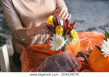 Beautiful autumn floral bouquet in a pumpkin vase. Preparing for Halloween. Table setting for the wedding