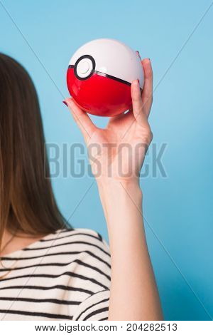 Ufa, Russia - July 8, 2017: woman holding pokeball. pokemon go multiplayer game with elements of augmented reality. Catching the Vaporeon pokemon