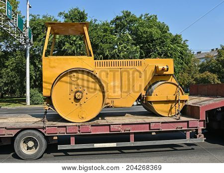 Old steamroller on a trailer vehicle in summer