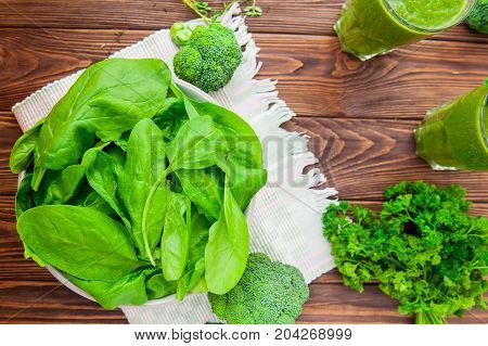 Top View Fresh Spinach Leaves With Water Drops In Ceramic Bowl And Other Green Herbs, Broccoli And S