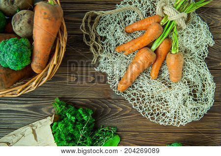 Top View Bunch Of Fresh Organic Dirty Carrots And Oher Purchased Products From Farm Market On The Wo